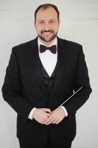 Dr. William Plummer in a tuxedo with conductor's baton